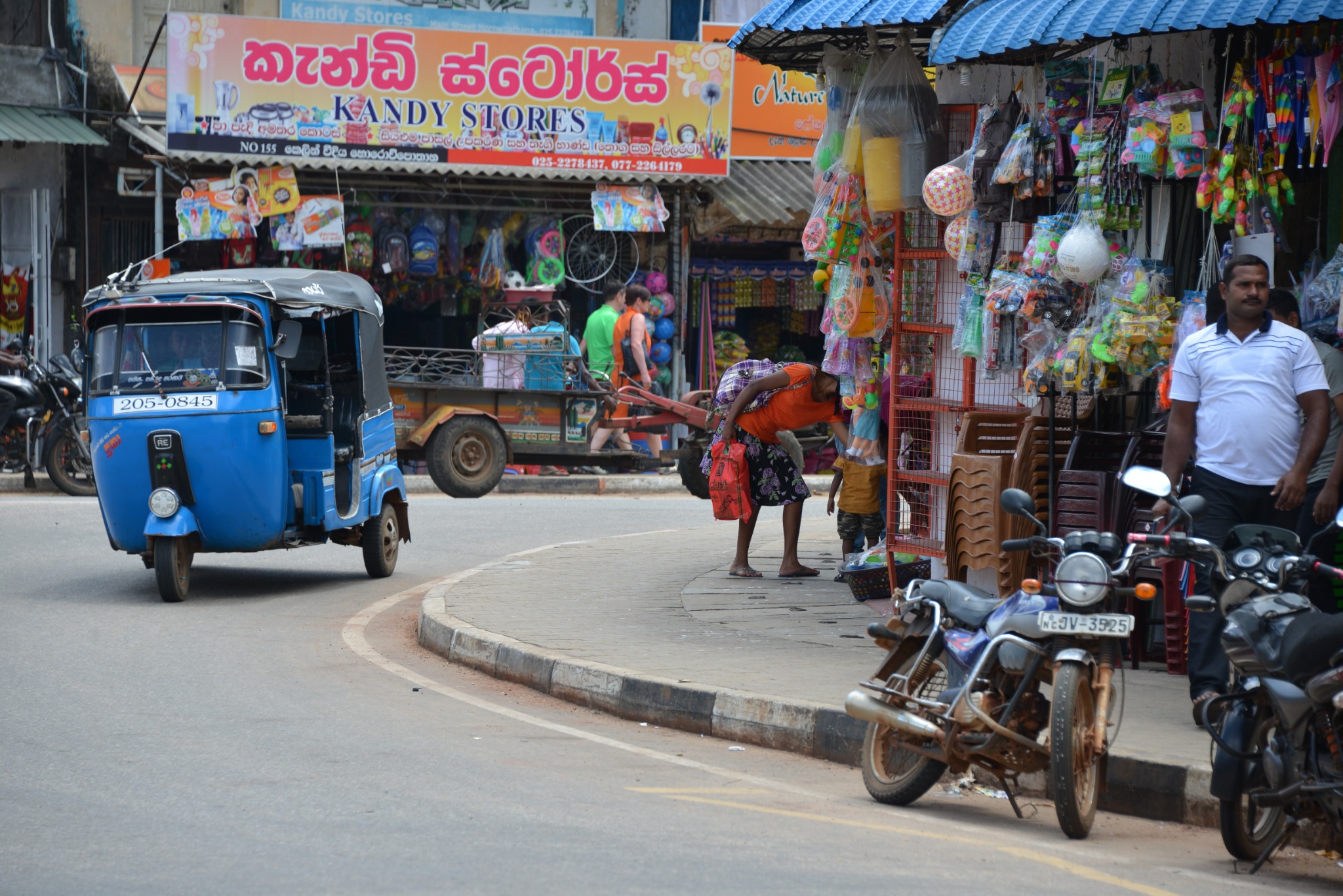 Tuk-Tuk und kleine Geschäfte an einer Straße in Sri Lanka, 2016